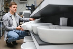 Middle age man choosing bathroom sink and utensils for his home.