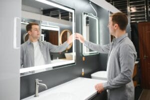 Man choosing new bathroom furniture at the plumbing shop with lots of sanitary goods.