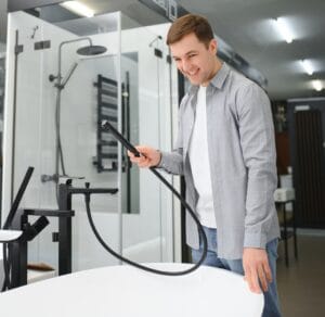 Man customer choosing ceramic bath in bathroom furniture store.