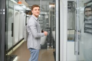 man choosing shower cabin and utensils for his home bathroom.