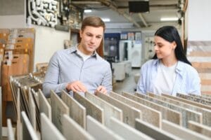 Couple looking ceramic and tiles for their new home floor. They are choosing in furnitures store.